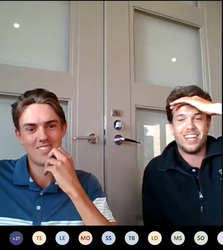 Two men are sitting in front of a door with the letters tb and ld visible