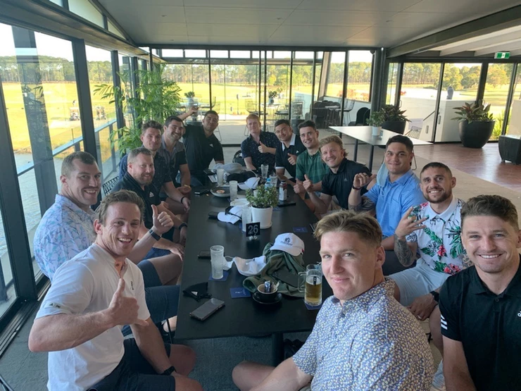 a group of men are sitting around a table in a room .